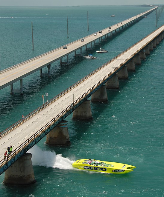 The turbine-powered Miss Geico leads a field (it’s way behind) home in the recent Florida Keys offshore race. The big catamaran is seen charging beneath one of the many bridges and and causeways leading down through the Florida Keys.  © SW